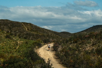 Man hiking with NOMAD backpack between hills