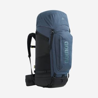 A man is wearing a dark blue NOMAD Batura 70 Premium backpack with a hip belt and adjustable shoulder straps.
