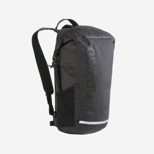 Woman wearing a black NOMAD Mahon Pro 18 Daypack on her back, seen from the side against a white background.