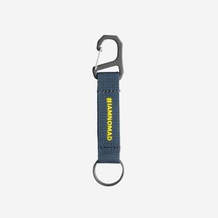 NOMAD keychain in dark blue with clip and metal ring, featuring yellow #IAMNOMAD text.