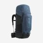 Man draagt NOMAD Batura 70 Premium rugzak in donkerblauw met heupband en verstelbare schouderriemen