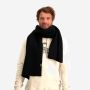 NOMAD Turoa Scarf heren sjaal zwart gebreid gedragen door man over lichte trui
