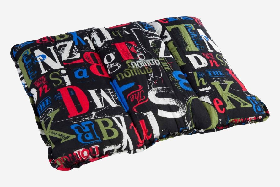 NOMAD Wollip multifunctional black travel pillow with colorful letters and prints on a rectangular design.