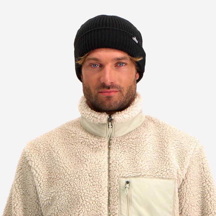 Man draagt zwarte NOMAD Turoa Beanie herenmuts met gebreide structuur