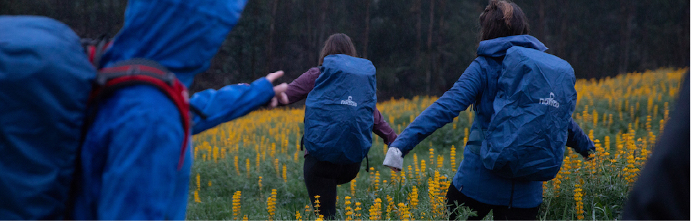 Gruppenwanderung durch Blumenfelder in NOMAD Outdoor-Ausrüstung