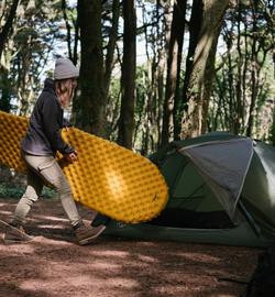 Een gezellige kampeersetting in de buitenlucht met een tent en slaapuitrusting van NOMAD voor het ultieme buitenleven.