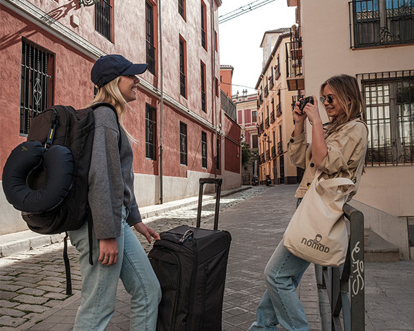 Two girls with a shopper bag taking a holiday photo of each other