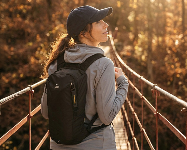 Vrouw met rugzak om op een loopbrug
