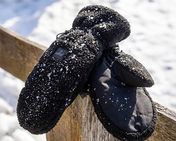 Handschuhe aus Teddy-Stoff auf einem Holzzaun