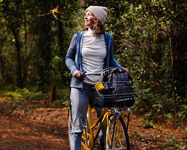 Vrouw op fiets met NOMAD herfstproducten